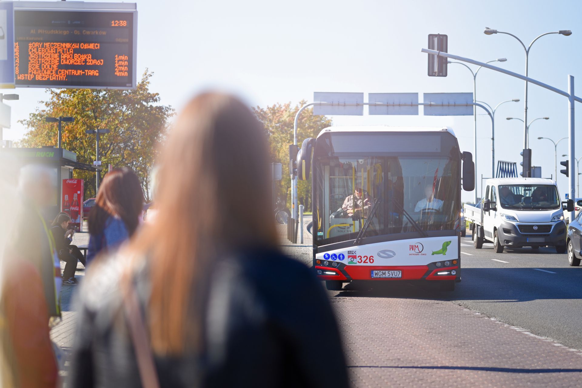Na zdjęciu: Pasażerowie oczekujący na przystanku na przyjazd autobusu; autobus nadjeżdżający na przystanek